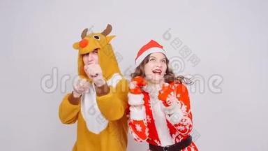 年轻女子戴着<strong>圣诞</strong>帽，男子穿着鹿的狂欢节服装。 <strong>欢乐</strong>、节日和<strong>圣诞</strong>节
